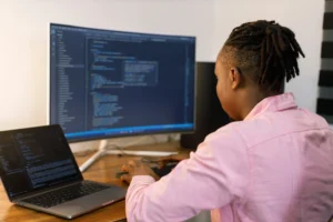 A person sitting in front of a computer on a desk taking a SaaS course.