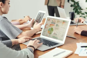 Two data architects review the average salary for their industry. They are both looking at a computer screen.